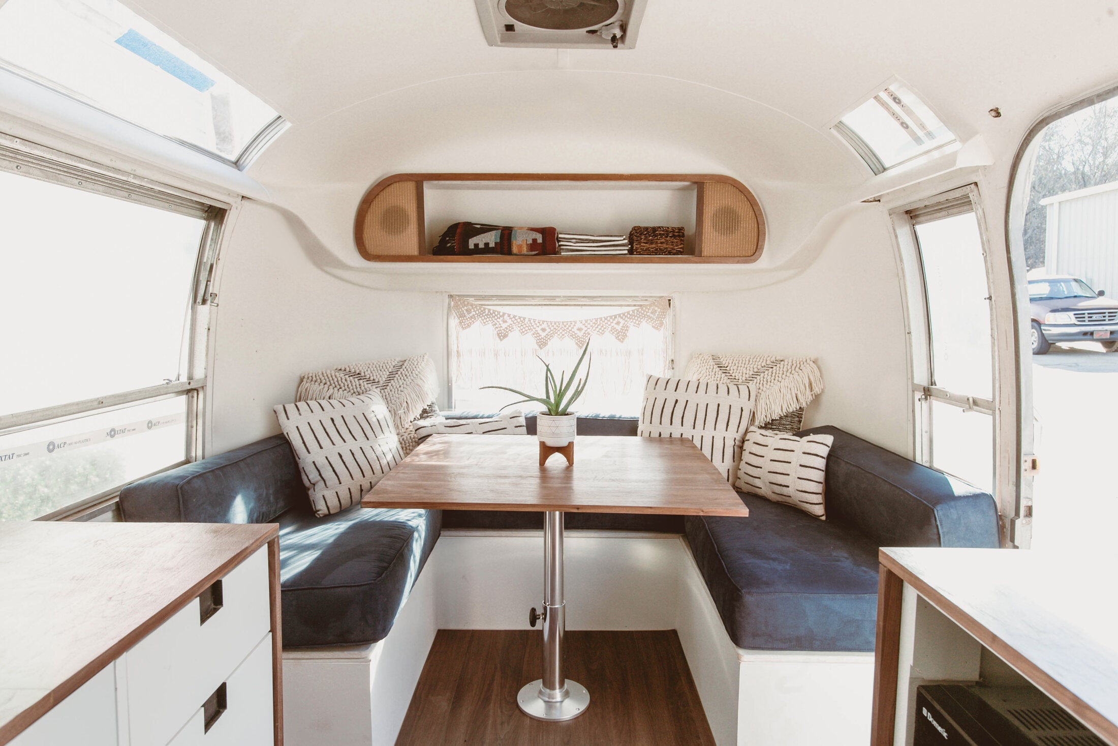 Bright NuAbode Airstream interior with custom dining lounge
