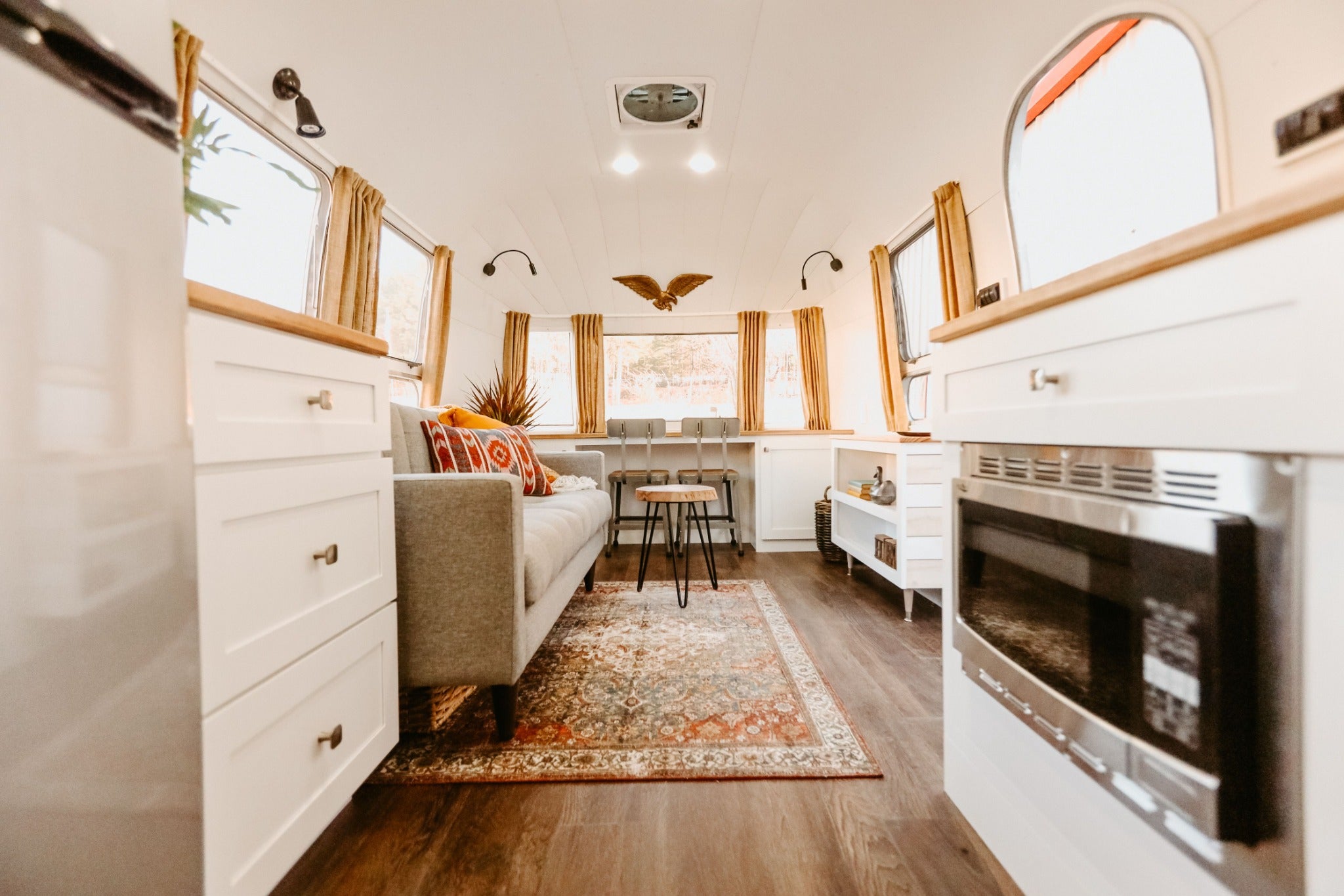 Bright renovated Airstream lounge with custom cabinetry, fireplace and warm residential finishes